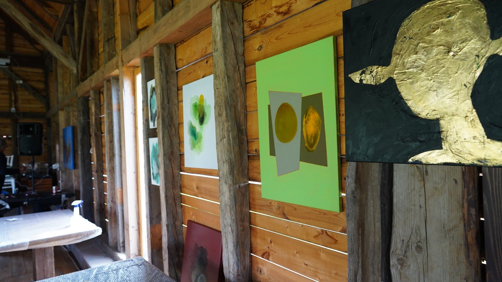 Art camp paintings displayed on rustic wooden walls at Daniel Castle